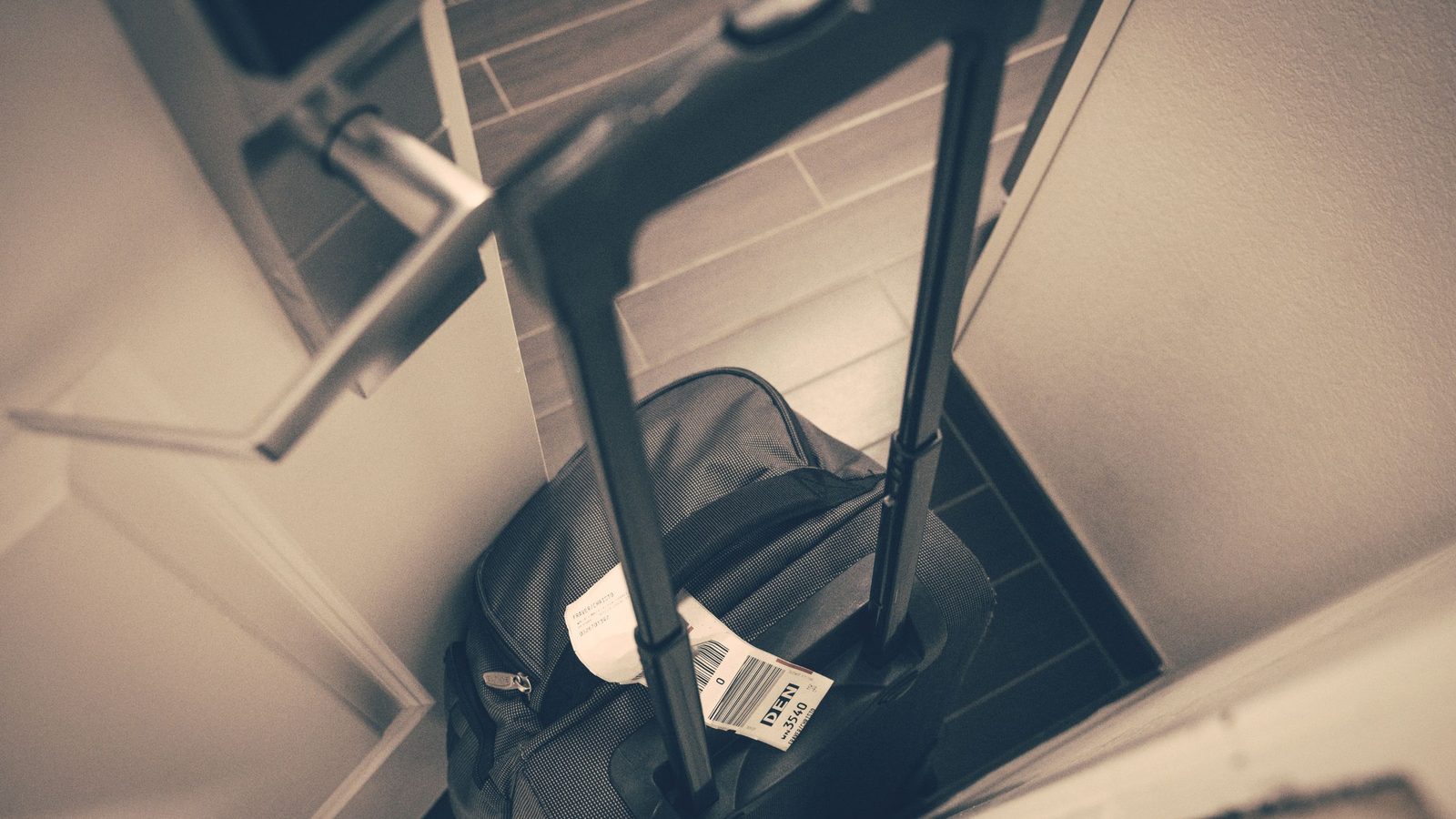 Valigia con l'etichetta del viaggio appoggiata accanto alla porta di un alloggio