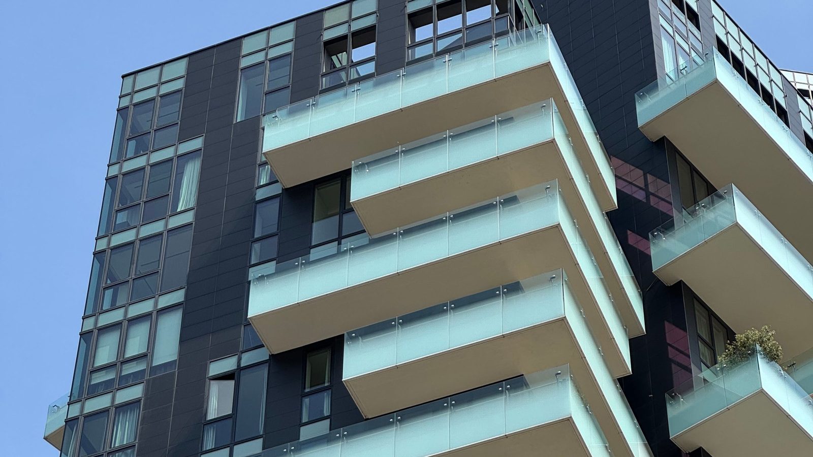 Palazzo residenziale moderno di Milano con balconi sovrapposti in vetro